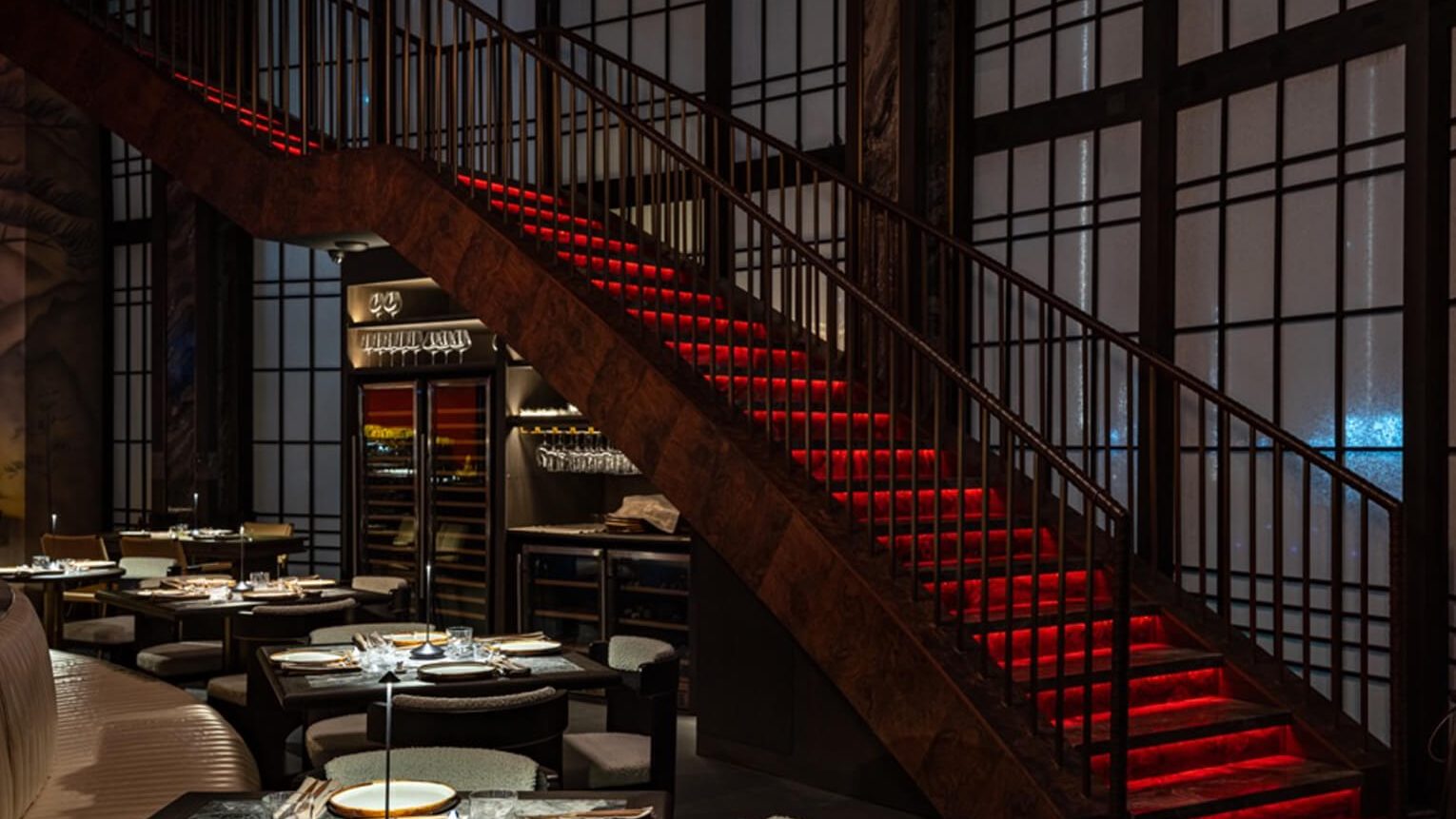 The dining room at Alba laid for a private dinner beneath the red staircase.