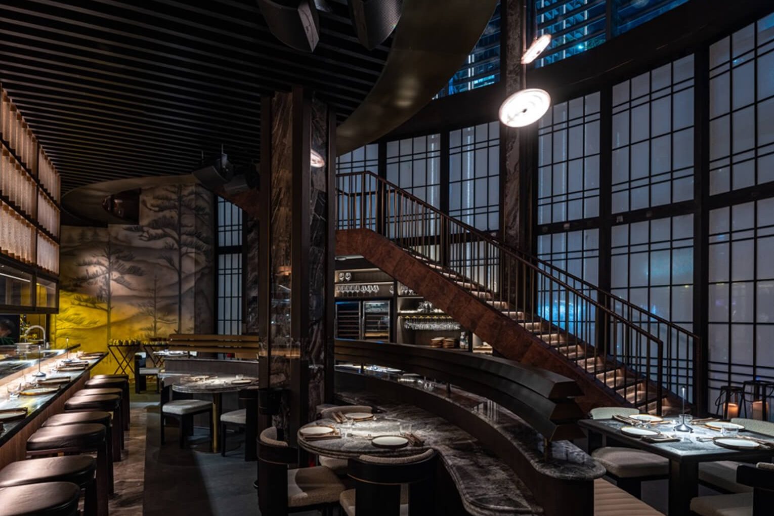 Alba's dining room seen from above, its staircase curving down past the windows.