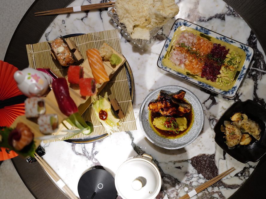 A shared table at Alba seen from above, sushi and robata plates across it.