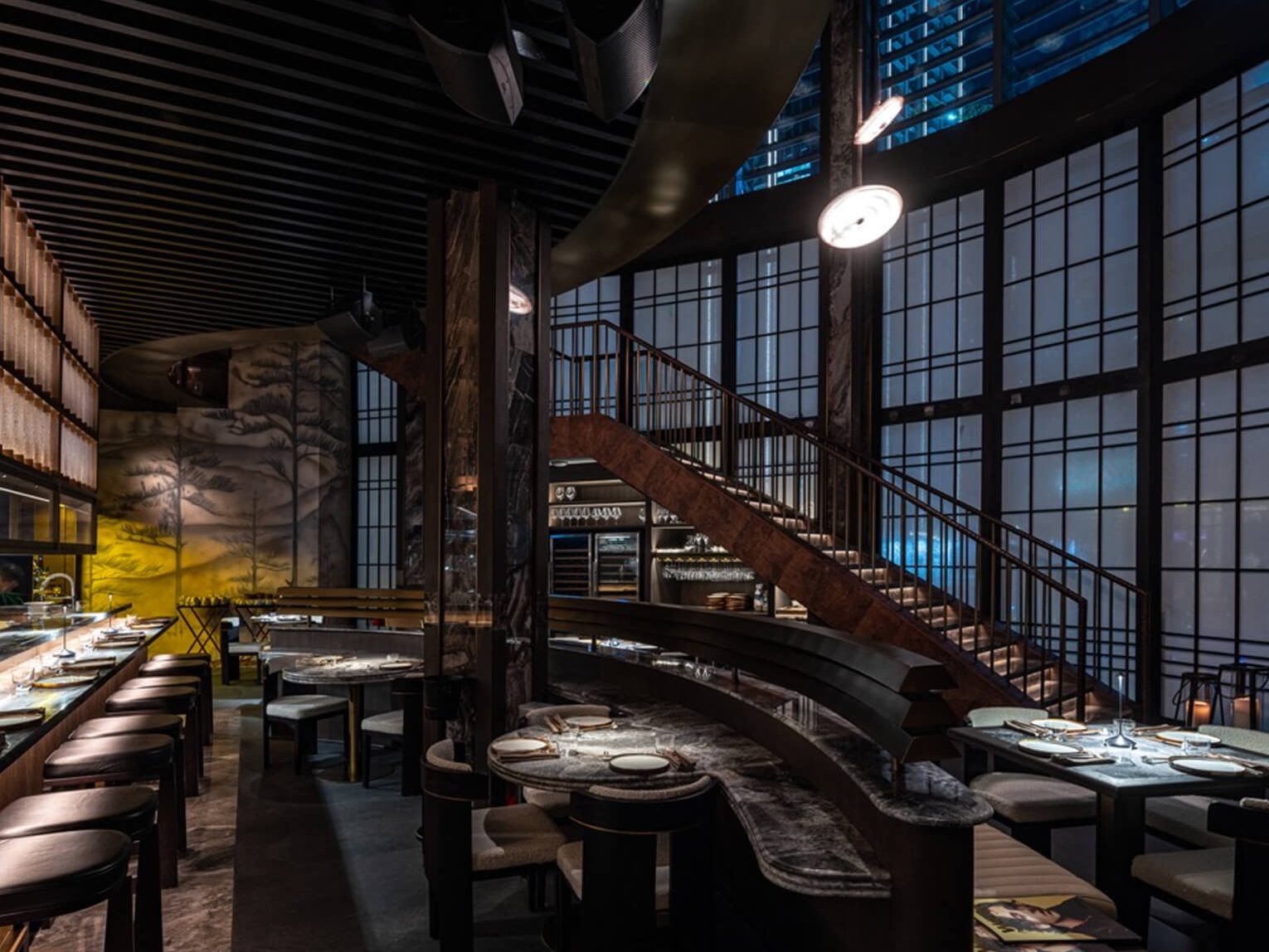 Alba's dining room seen from above, its staircase curving down past the windows.