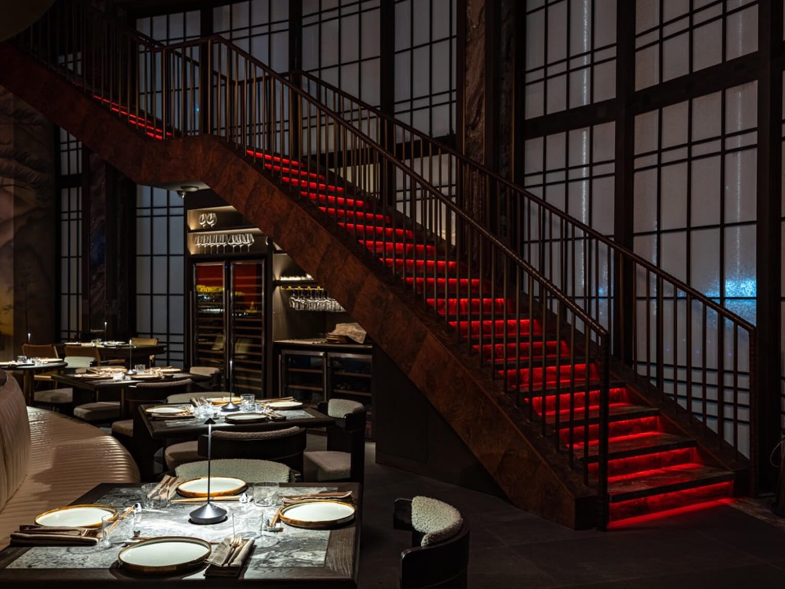 The dining room at Alba laid for a private dinner beneath the red staircase.