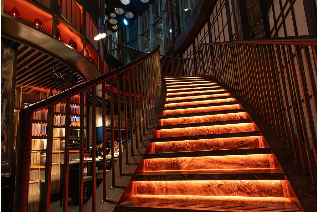 The lit staircase inside the Alba building, its treads glowing in the dark.
